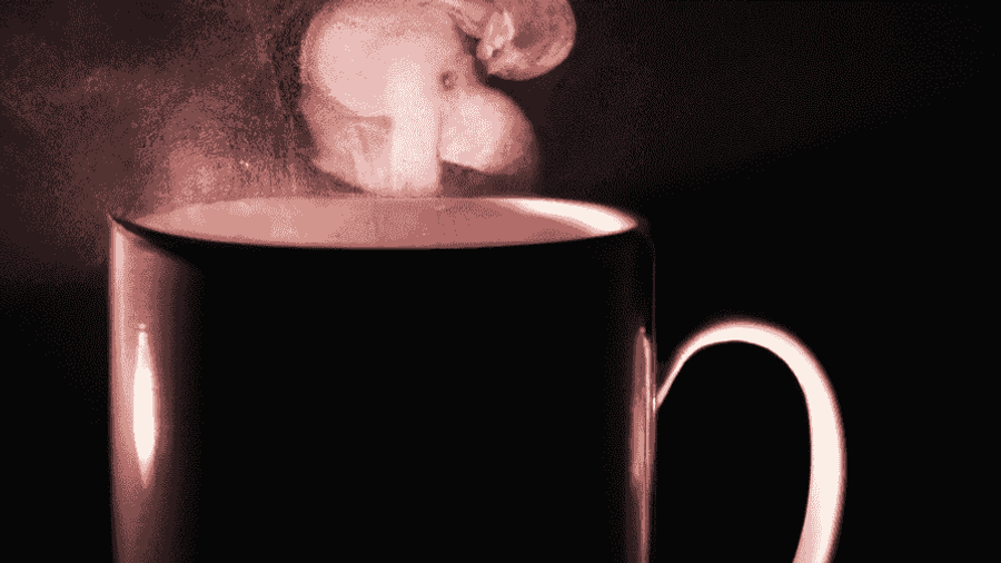 A picture of a hot cup of coffee with steam rising from it.