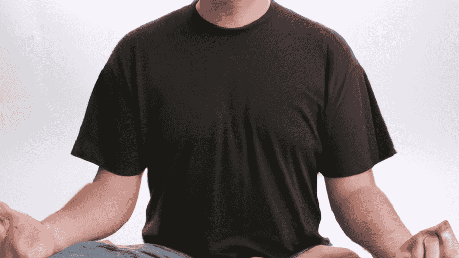 An image of a person sitting cross-legged, eyes closed, and peacefully meditating in a tranquil setting.