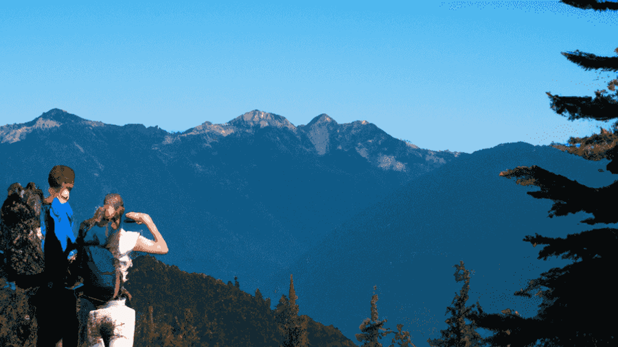 An image of hikers taking in breathtaking mountain views and basking in the sunshine.